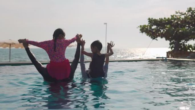 快乐的亚洲家庭: 亚洲男孩和女孩骑着父亲和母亲的脖子，一起玩耍进入游泳池
