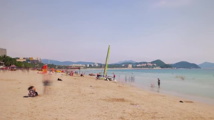 日落三亚著名的大东海拥挤海滩全景4k延时中国海南岛
