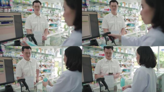 亚洲男子客户扫描付款二维码在药房购买药物。