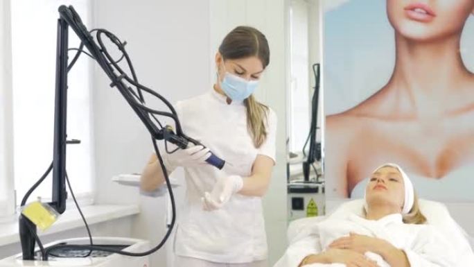 蒙面美容师-皮肤科医生为美容医学诊所的患者执行硬件激光脱毛。激光脉冲清洁皮肤。硬件美容。消除颜料。