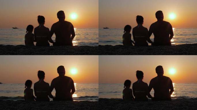 父母带着孩子享受海边或海边的日落。