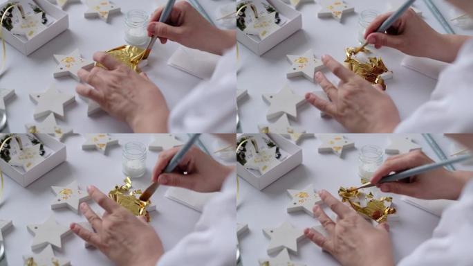 应用金箔。女艺术家用一张金色装饰黄金石膏工艺
