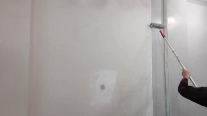 大师用滚筒刷将墙壁涂成灰色