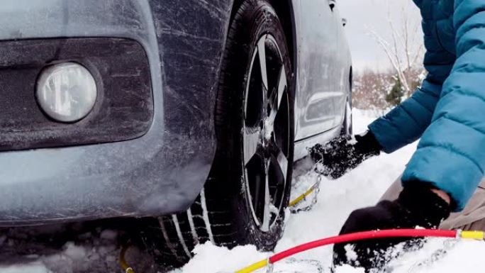 父子俩陷在雪地里，不能在轮胎上放防滑链