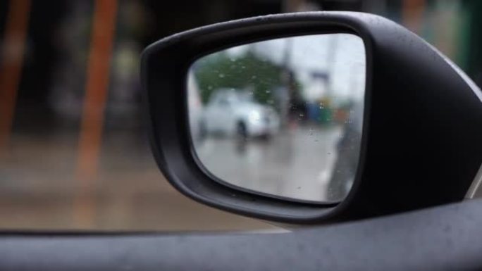 在雨天打开车窗看侧镜。