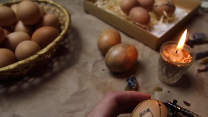 女性手持鸡蛋和油漆皮桑卡。准备用抗蜡法绘画乌克兰复活节彩蛋，装饰有民间设计。复活节彩蛋。图形