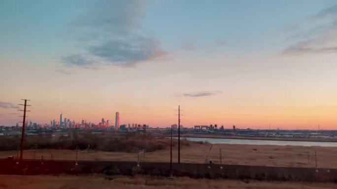 日落时火车内的城市摩天大楼的平移镜头