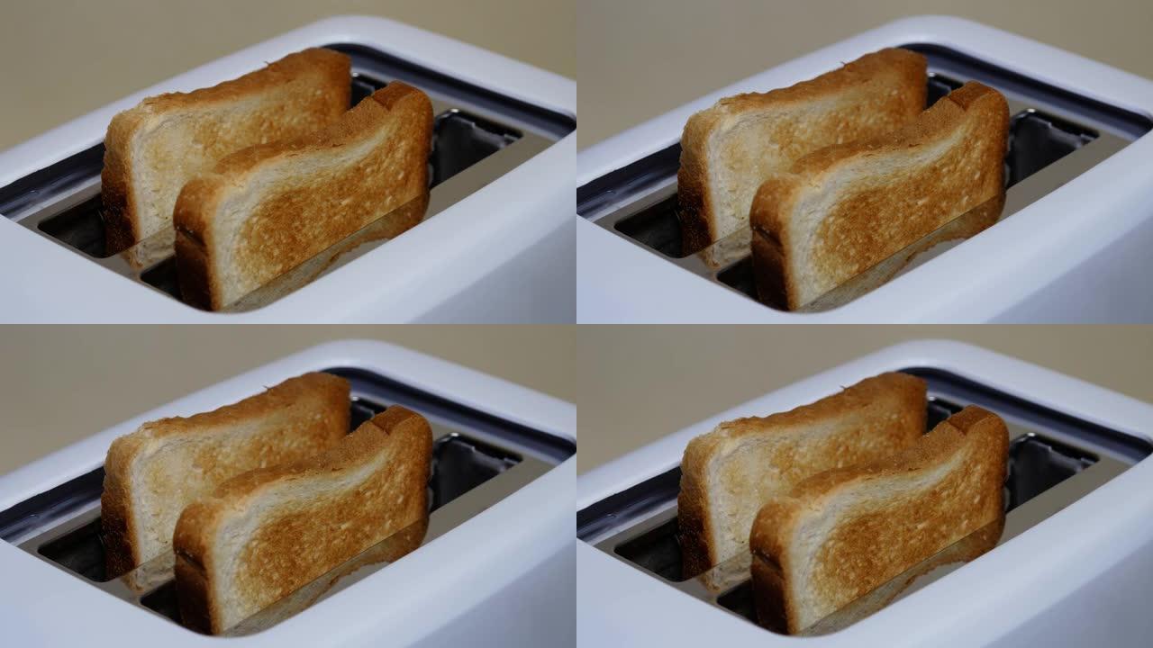 关闭从电烤面包机中弹出的切片烤白面包。