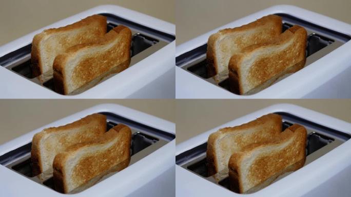 关闭从电烤面包机中弹出的切片烤白面包。