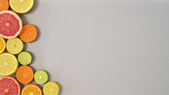 银色主题左侧切片健康新鲜柑橘类水果排列。停止运动平铺
