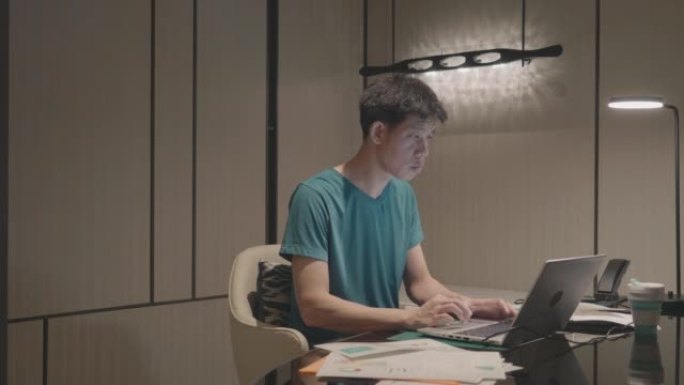 亚洲男子在家工作，使用笔记本电脑库存视频...