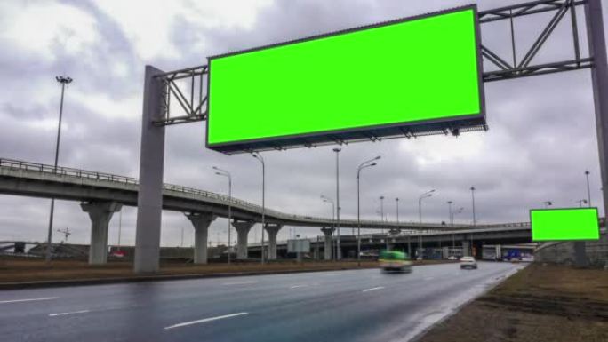 高速公路附近的大型广告牌绿屏。汽车，云，延时。