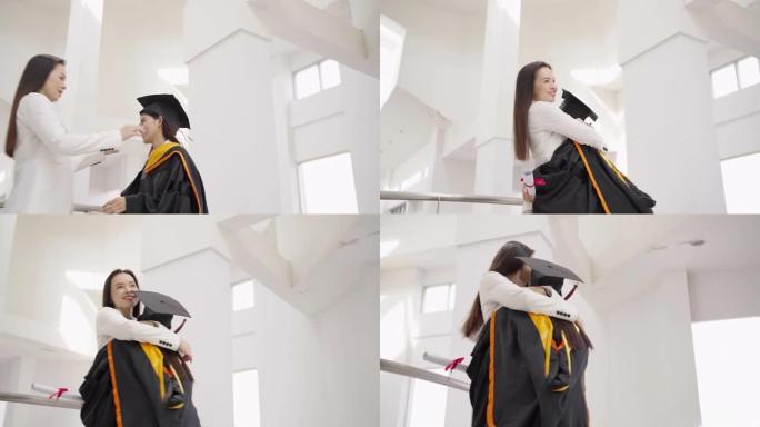 毕业生的女儿走路拥抱妈妈在毕业那天表达喜悦