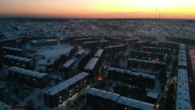 美丽的橙红色日落背景下冬季小镇的空中俯视图