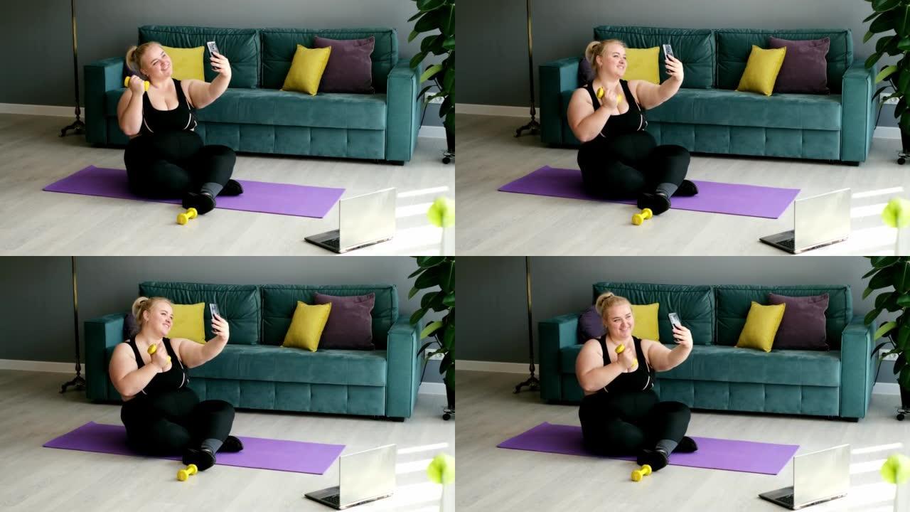 一名肥胖的妇女在运动之家锻炼期间用手机为相机摆姿势拍照。一个懒惰的女人分享了她的健身课程的照片，在那