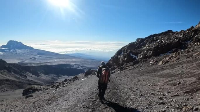 那家伙从乞力马扎罗山降下来。从后面看。美丽的山景。