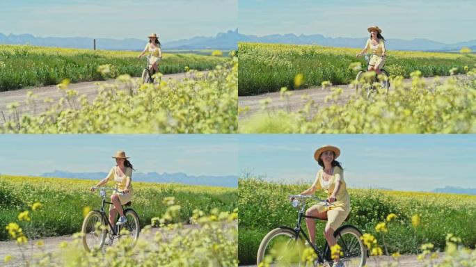 4k视频片段，一名年轻女子在乡村花田旁的一条土路上骑自行车
