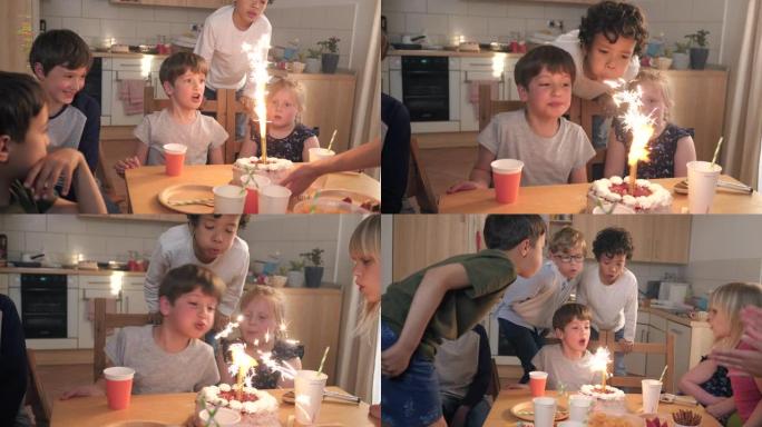孩子们在生日蛋糕上吹着闪闪发光的烟花蜡烛