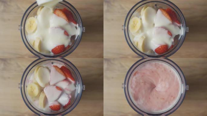 将酸奶倒入带有香蕉和草莓片的搅拌机中