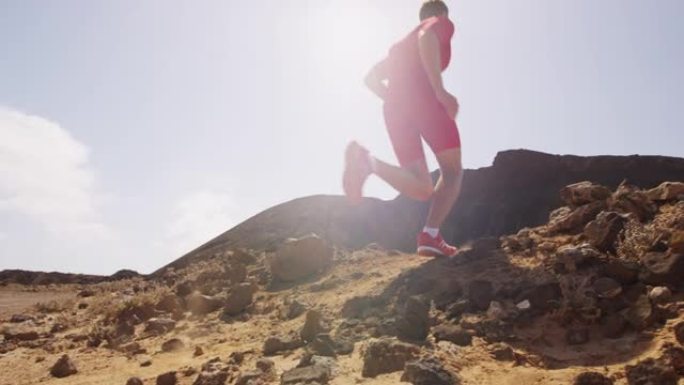 奔跑的人在沙漠中奔跑-男性运动员跑得很快。慢动作中腿部和跑鞋的特写