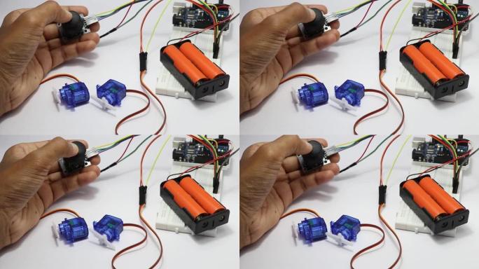 拇指操纵杆模块控制原型电子电路中的微型伺服系统，显示了实验室中一位年轻发明家的一些测试