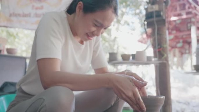 亚洲女性黏土艺术家在她的工作室里工作，用旋转的陶轮。可持续发展生活方式