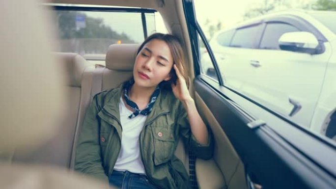 亚洲美女旅行者在城市旅行时坐在车里。迷人的年轻女性背包客感到悲伤和孤独，在泰国度假旅行中独自旅行。