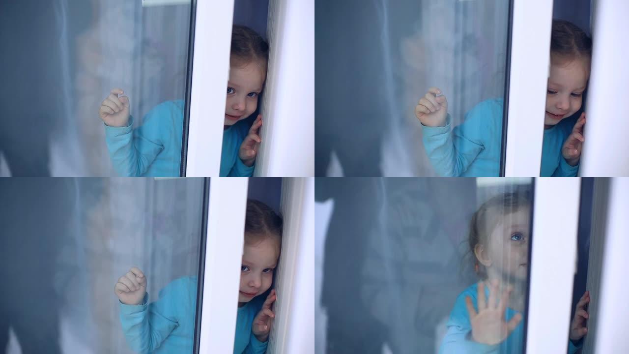 一个蓝眼睛的小女孩和她美丽的母亲坐在窗台上，冬天在乡间别墅里看着窗外