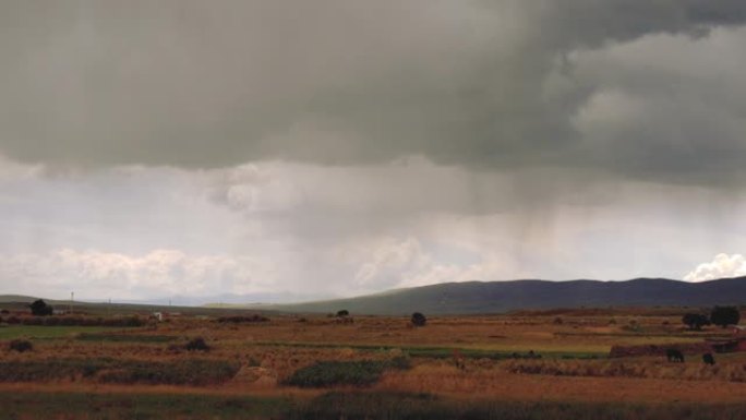 在暴风雨天气下，乌云密布的田野和山脉的景色