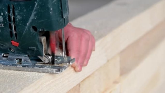 女人的手在特写镜头中用电动拼图切割木板。木工用工具在木头上，锯末飞，锯切成直线。亲手上门修理，锯木厂