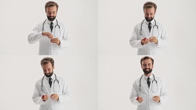 微笑的男子医生用听诊器打开药瓶，然后将其中一些药放在手中