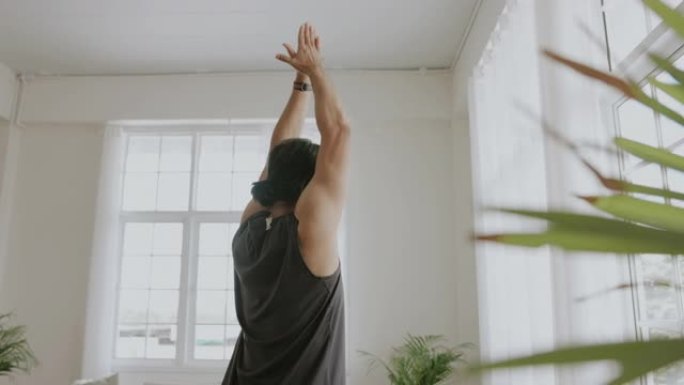 亚洲成年男子用瑜伽姿势伸手伸展。