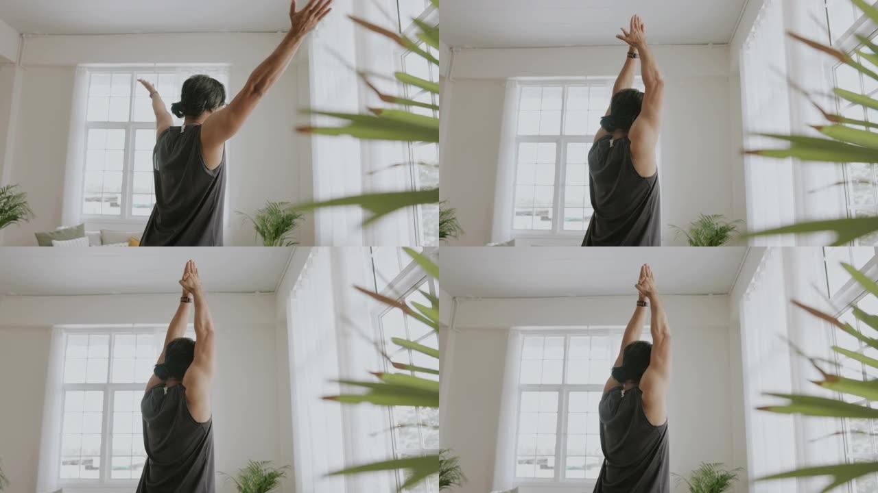 亚洲成年男子用瑜伽姿势伸手伸展。