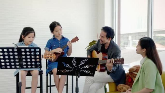 在音乐学校的课堂上，一位音乐老师在教音乐学校的孩子们学习吉他和弦。
