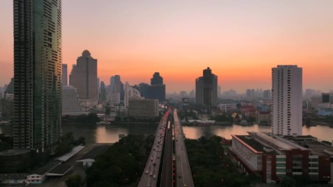 空中无人机在曼谷的超披亚河上的高速公路和地铁天空列车上的交通车灯的日出场景