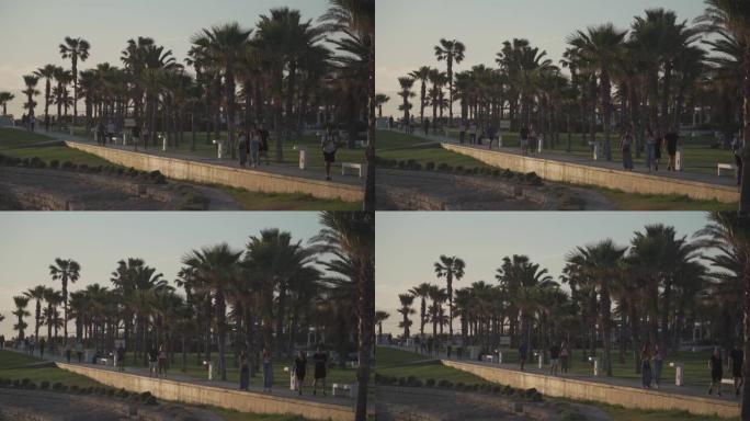 塞浦路斯。悲哀。2021年5月15日。晚上的长廊有棕榈树，沿着海边的酒店有一条长廊，人们散步。日落时