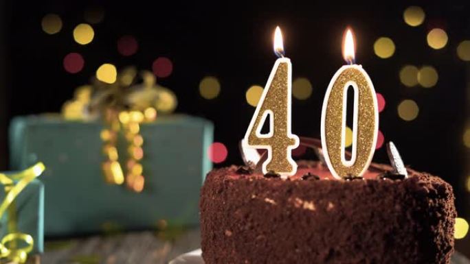 40岁生日，桌上甜蛋糕上的40号生日蜡烛。打火机上的火，吹灭节日蜡烛。