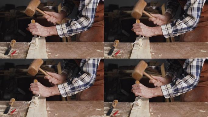 熟练的木匠用锤子和凿子雕刻木材。高质量4k镜头