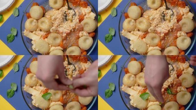 垂直桌面视频: 厨师在盘子里添加香料，土豆饺子配西红柿和羊乳酪