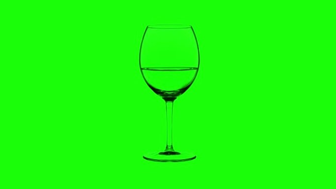 绿色背景上装满白葡萄酒的空玻璃杯