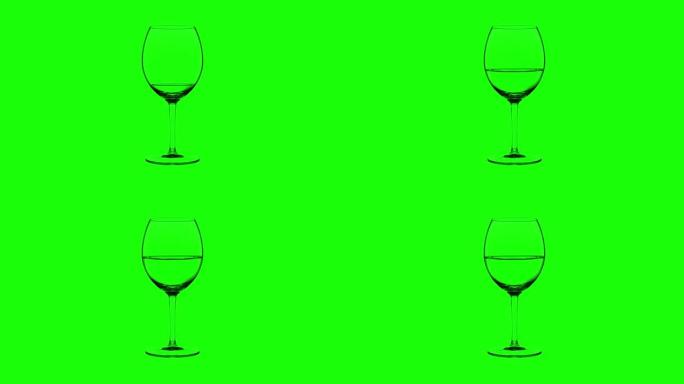 绿色背景上装满白葡萄酒的空玻璃杯