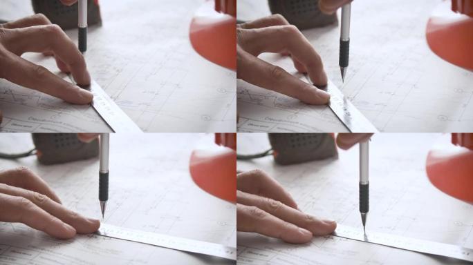 对工作图纸进行调整的过程。工程师的手使用尺子和自动铅笔对设计文档进行更改。标尺铅笔卷尺和安全帽。