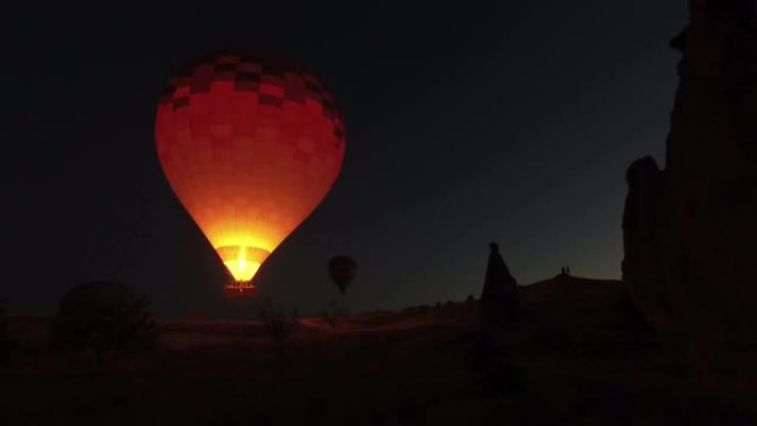 土耳其卡帕多细亚夜空中飞行的热气球。