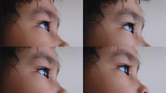 特写亚洲小孩仰望天空的肖像。美丽的棕色眼睛，长长的睫毛。