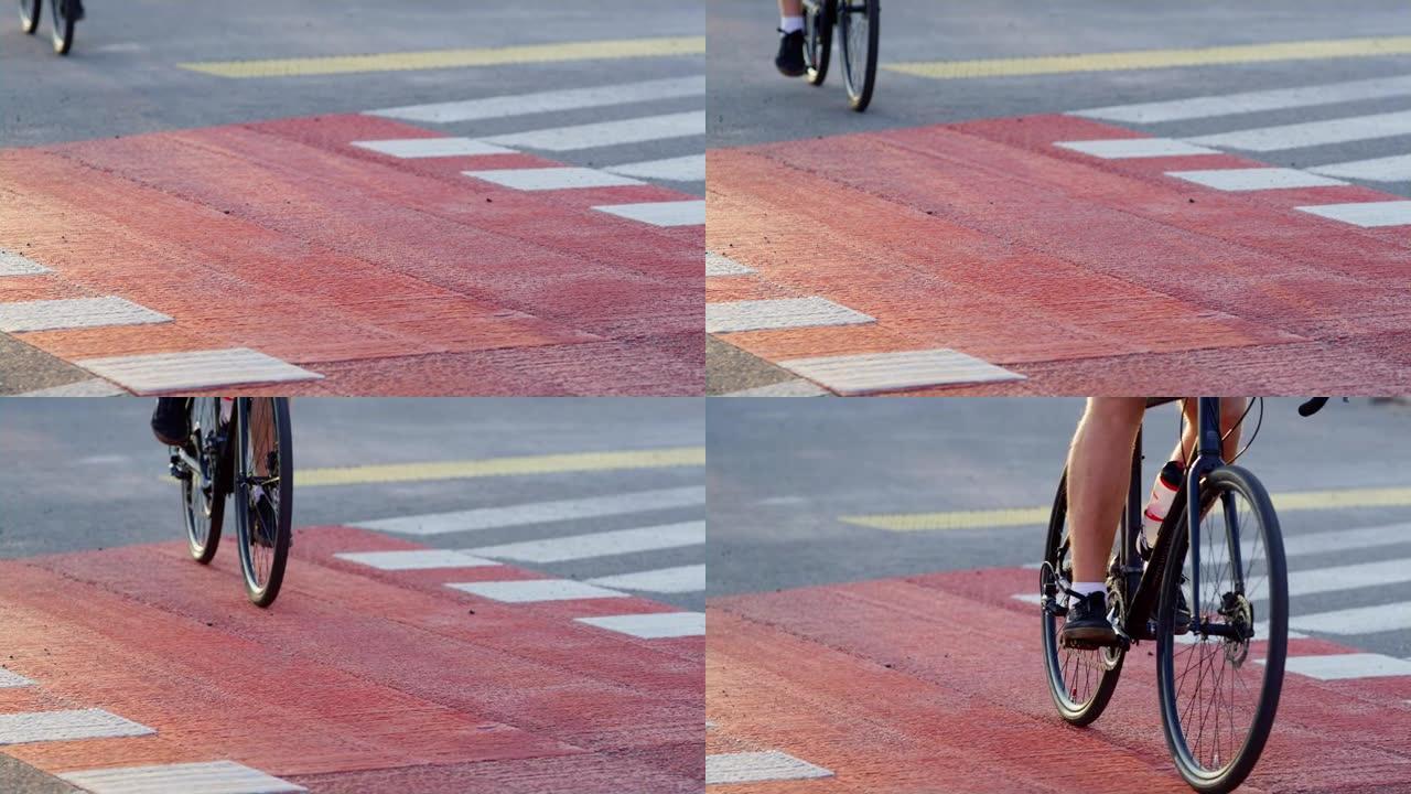 男子双腿踩踏城市人行横道红色自行车道特写。城市旅行者骑行