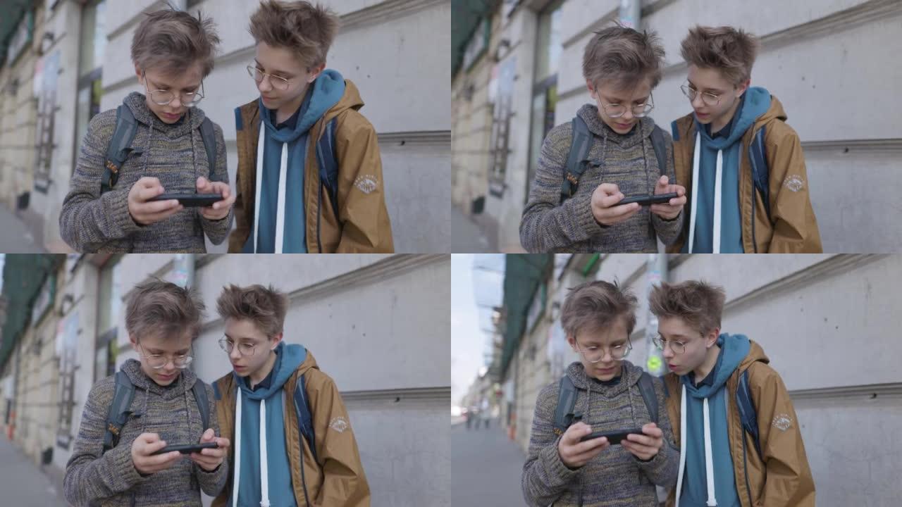 十几岁的男孩站在公共汽车站并使用智能手机