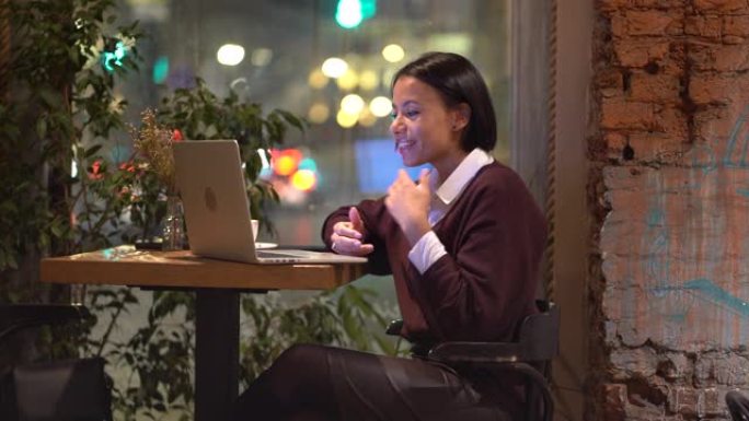 年轻友好的美国黑人女导师在咖啡馆远程工作，通过笔记本电脑在线授课