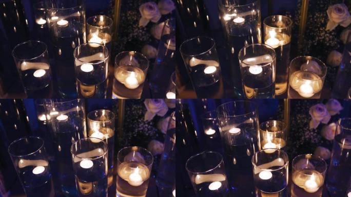 蜡烛在玻璃烧瓶中燃烧并照亮房间的特写镜头。摄像机在拍摄过程中移动