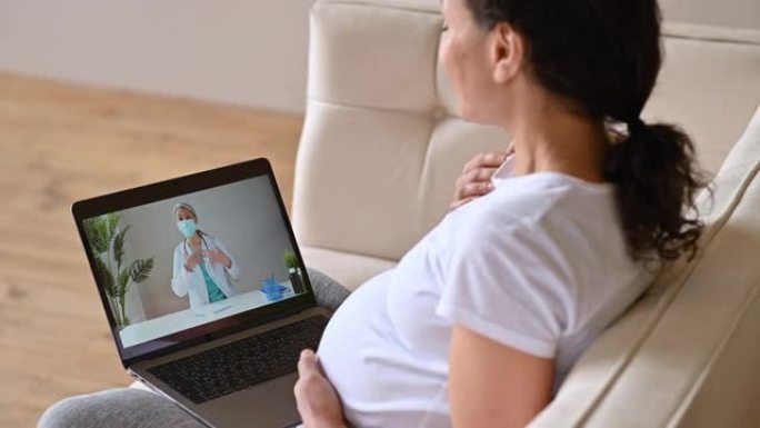 远程医疗帮助，在线医疗咨询。孕妇通过视频通话与女医生交谈使用笔记本电脑，接受医疗咨询，接受问题和建议