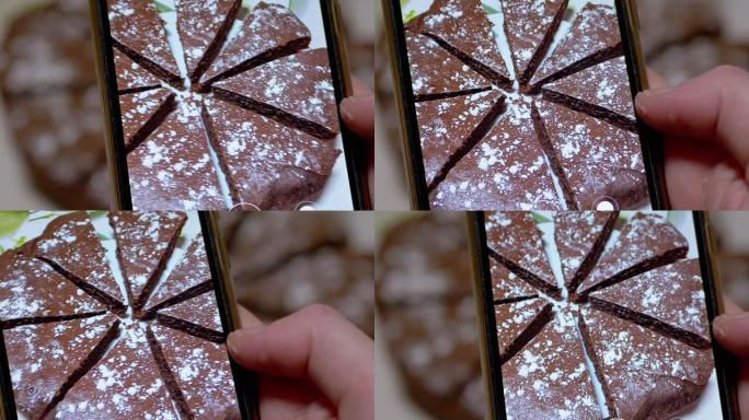女性手在智能手机上拍摄厨房巧克力派的视频。缩放